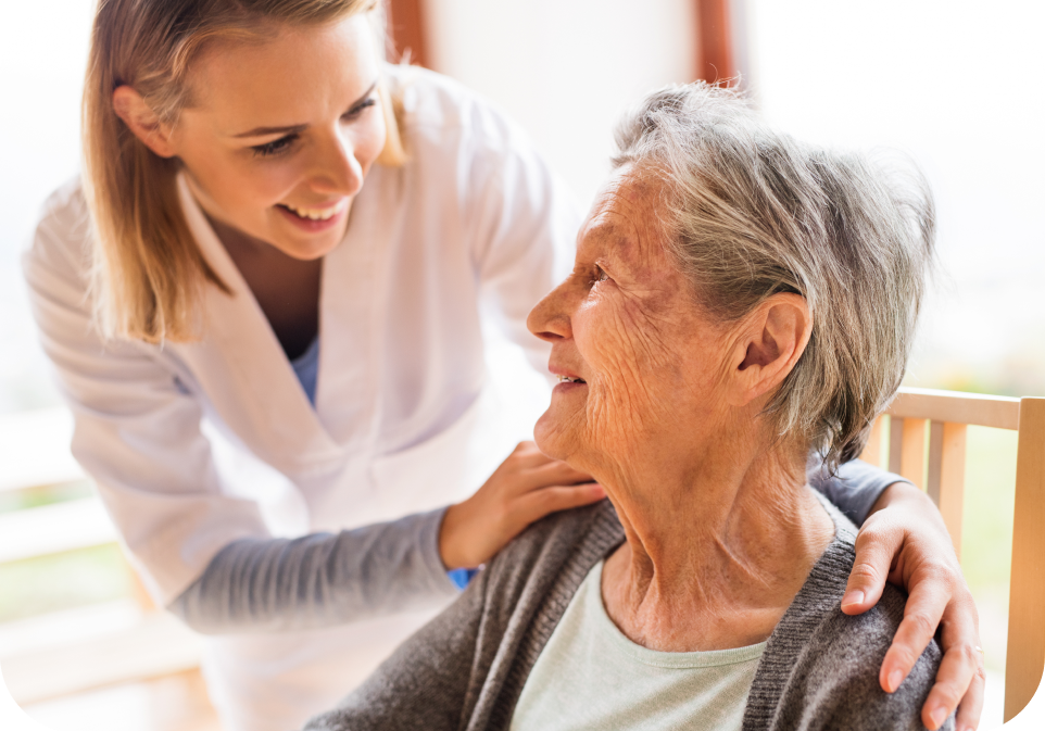 Caregiver comforting an elderly woman in a warm indoor setting