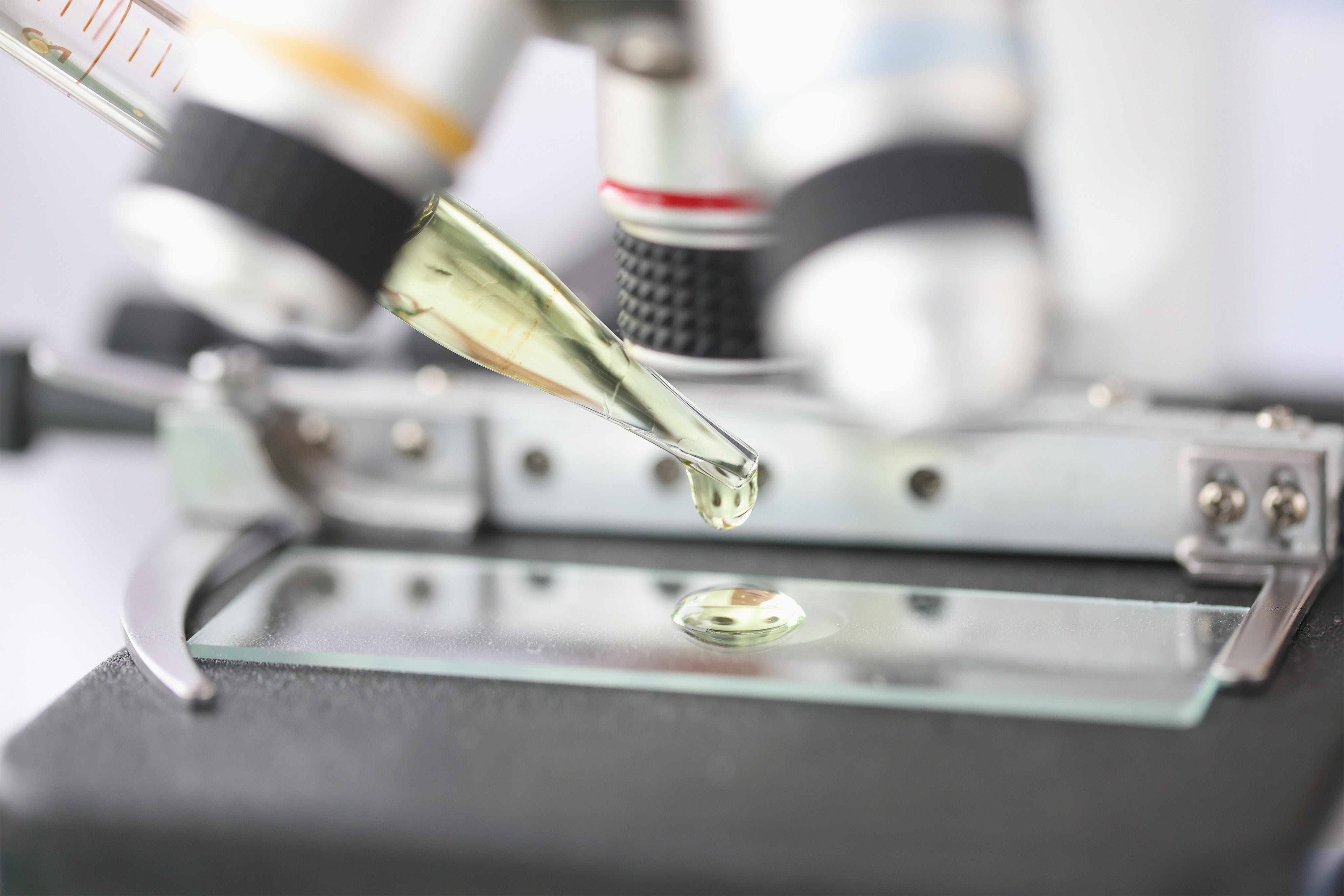 Microscope with a droplet on a slide, likely in a laboratory setting