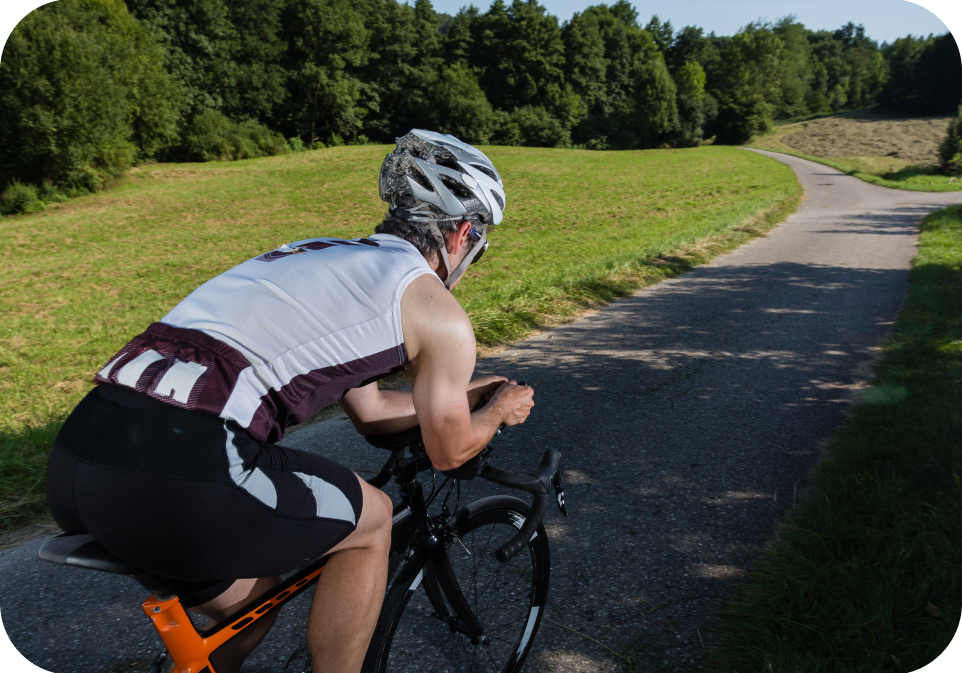 Person cycling on a path with greenery in the background