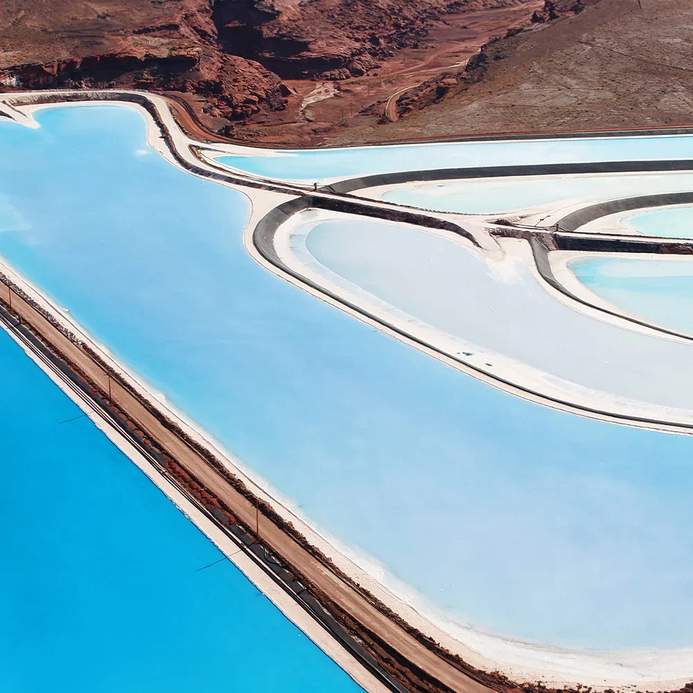 Aerial view of a salt lake with concentric circular patterns in the water, surrounded by desert landscape.